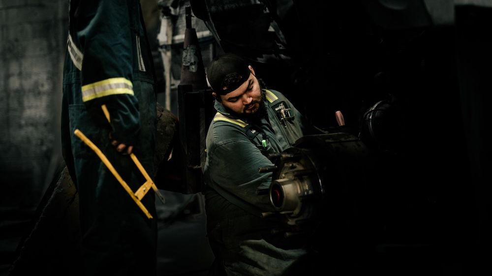 Technician working on a hydraulic line at Mach 6 in Edmonton